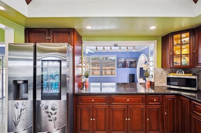 kitchen featuring backsplash, appliances with stainless steel finishes, and dark stone counters