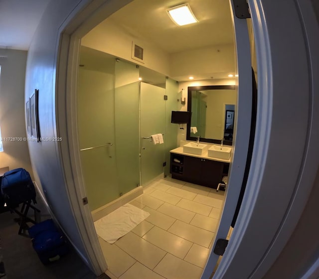 bathroom featuring a shower with shower door, tile patterned floors, and vanity