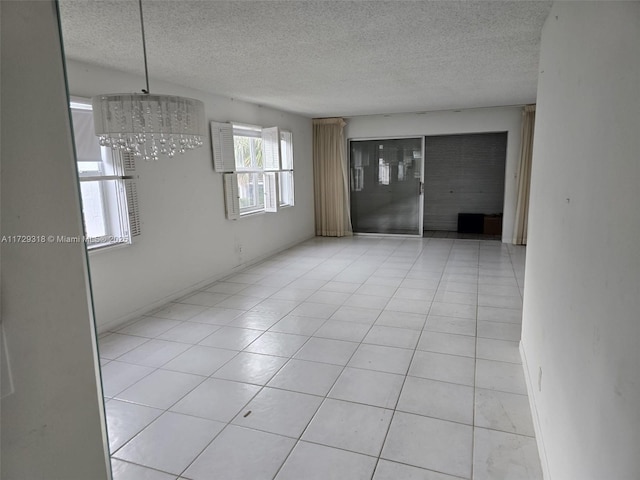 unfurnished room with light tile patterned floors and a textured ceiling