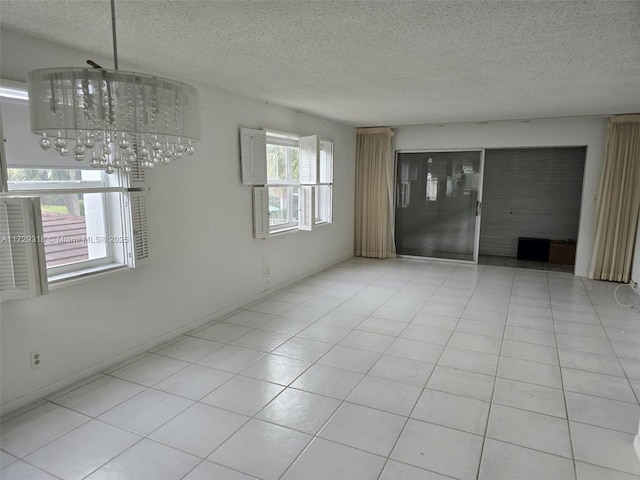 empty room with a chandelier and a textured ceiling