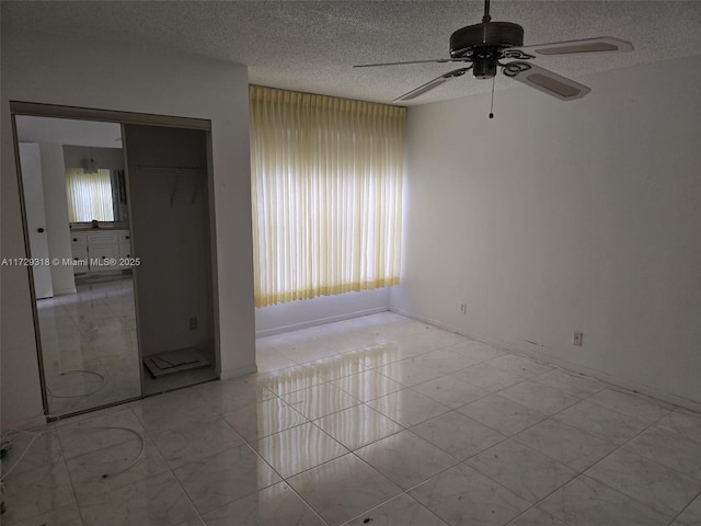 empty room featuring ceiling fan and a textured ceiling