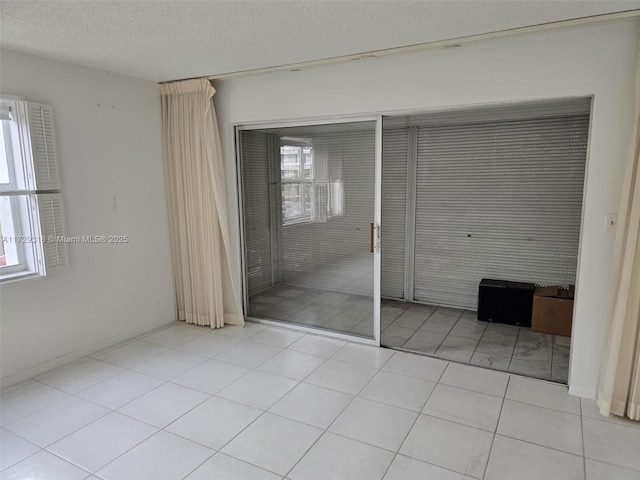 unfurnished bedroom featuring a textured ceiling, a closet, and light tile patterned flooring