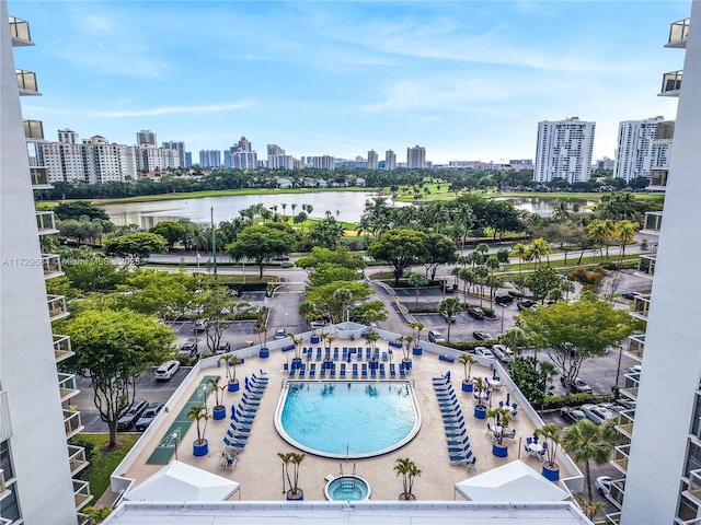 view of swimming pool with a view of city and a water view