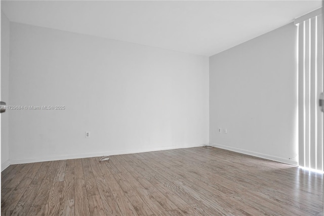 unfurnished room with wood finished floors and baseboards