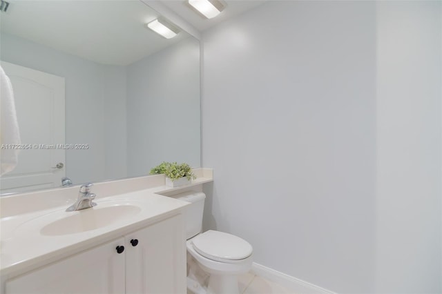 bathroom with toilet, vanity, and tile patterned flooring