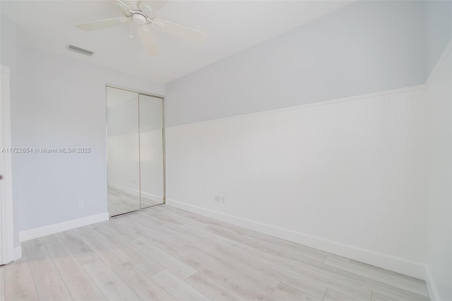 unfurnished bedroom with light wood-type flooring, a closet, and ceiling fan