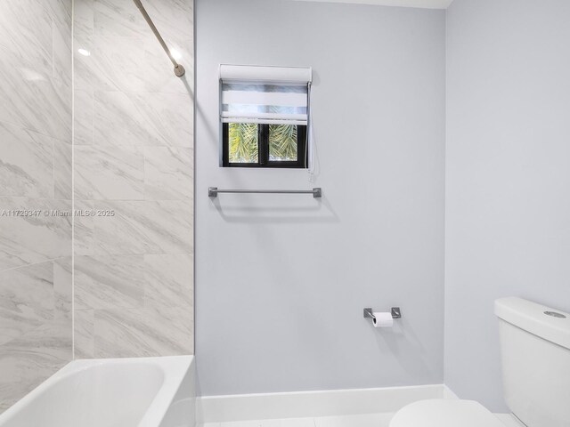 bathroom with toilet and tiled shower / bath combo