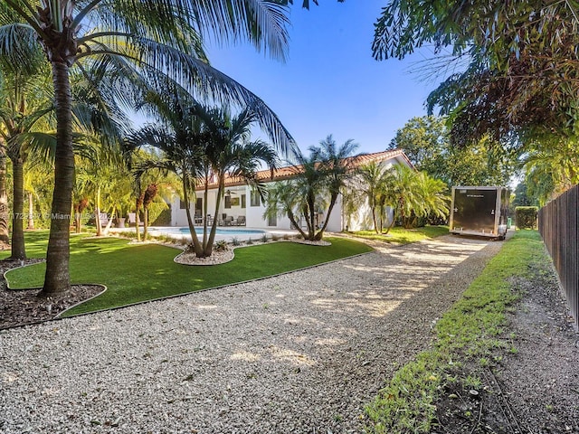 mediterranean / spanish home with a fenced in pool and a front lawn