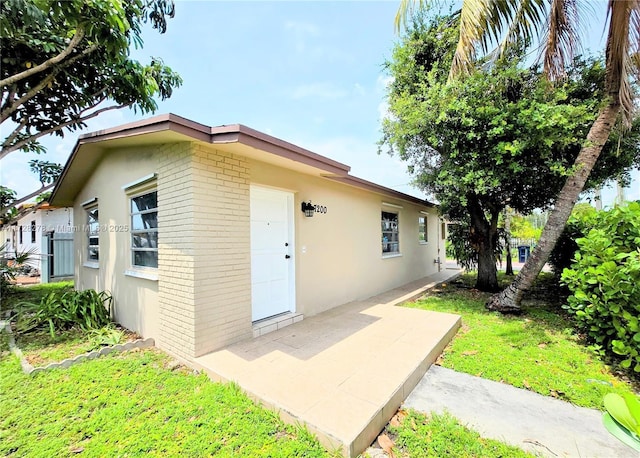 7200 NW 4th St, Miami, FL 33126 - doorway to property featuring brick siding and stucco siding