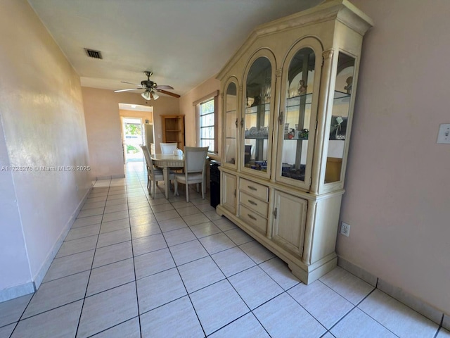 unfurnished dining area with light tile patterned floors and ceiling fan