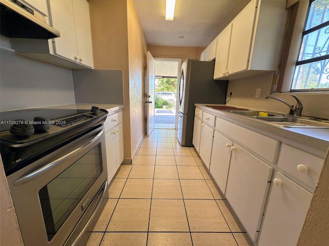 kitchen featuring light tile patterned floors, sink, white cabinetry, and appliances with stainless steel finishes