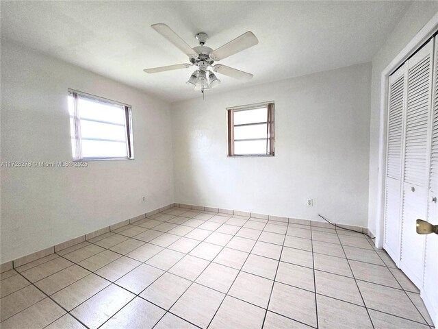 7200 NW 4th St, Miami, FL 33126 - unfurnished bedroom with a closet, multiple windows, light tile patterned floors, and a ceiling fan