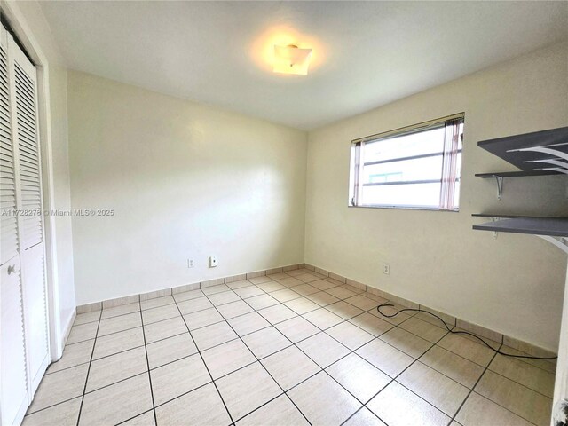 7200 NW 4th St, Miami, FL 33126 - unfurnished bedroom featuring light tile patterned floors, a closet, and baseboards