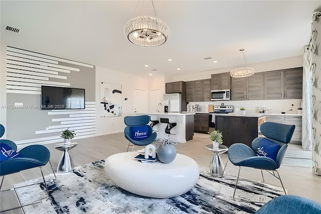 living room with light hardwood / wood-style flooring and a chandelier