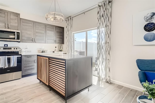 kitchen with pendant lighting, an inviting chandelier, appliances with stainless steel finishes, and sink