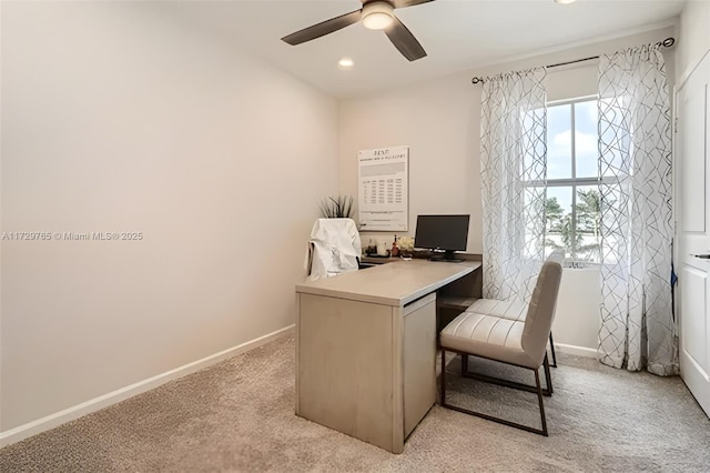 carpeted office space featuring ceiling fan