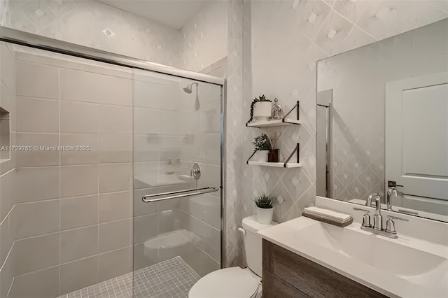 bathroom with toilet, tile walls, walk in shower, and vanity