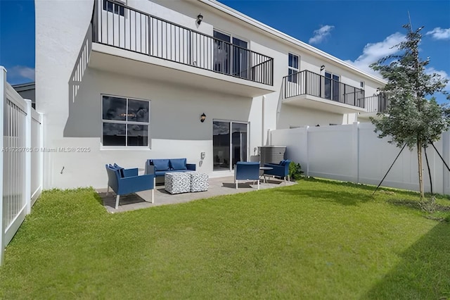 rear view of property featuring outdoor lounge area, a lawn, and a patio