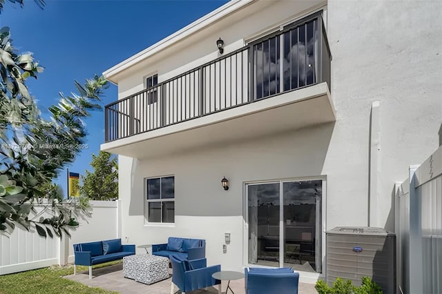 back of house featuring a balcony, a patio area, and an outdoor hangout area