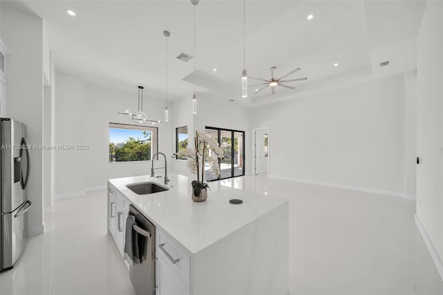 kitchen featuring sink, decorative light fixtures, white cabinets, an island with sink, and stainless steel appliances