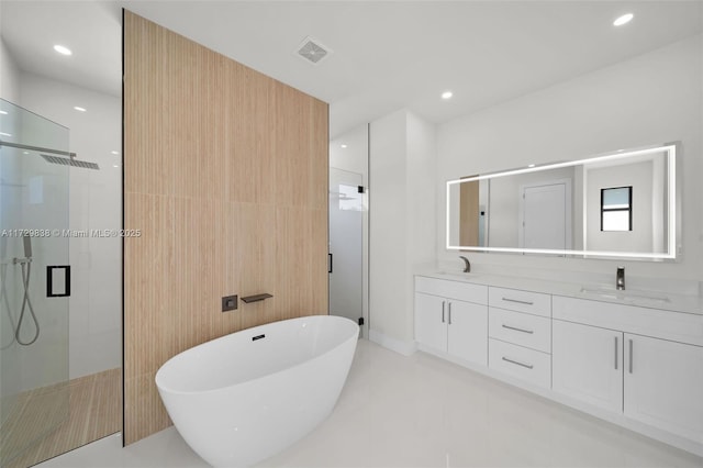 bathroom with tile patterned flooring, vanity, and plus walk in shower