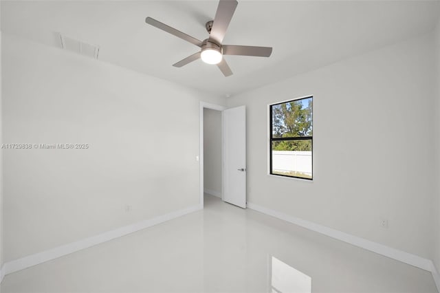 empty room with ceiling fan and concrete flooring