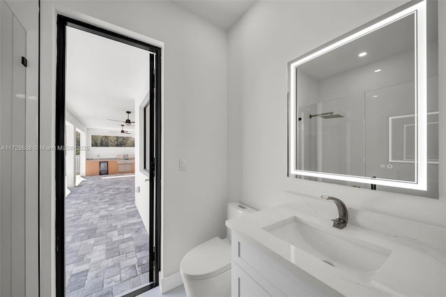 bathroom featuring vanity, toilet, and a shower with door