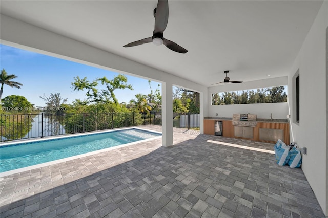 view of swimming pool with ceiling fan, a patio, exterior kitchen, and area for grilling