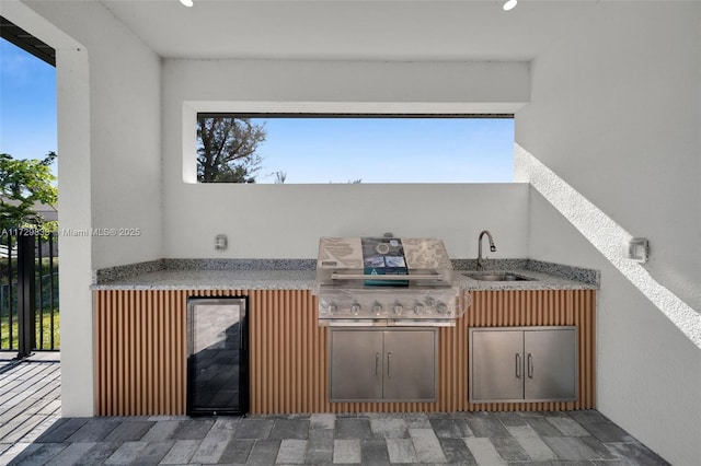 view of patio featuring sink, a grill, beverage cooler, and area for grilling