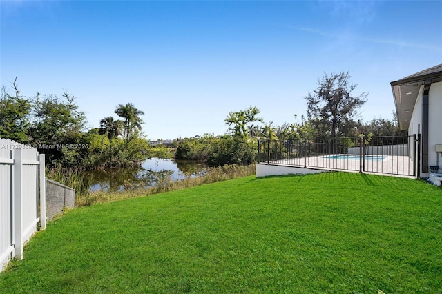 view of yard featuring a fenced in pool and a water view