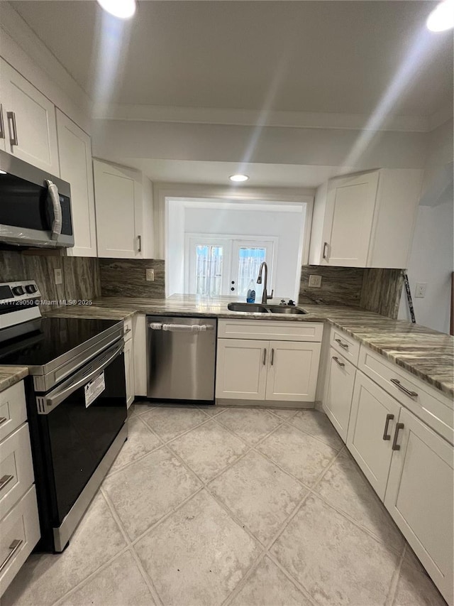 kitchen featuring sink, stainless steel appliances, white cabinets, and light stone countertops