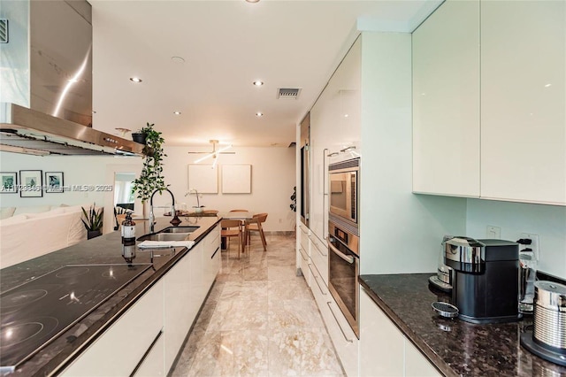 kitchen featuring sink, white cabinetry, appliances with stainless steel finishes, and island range hood