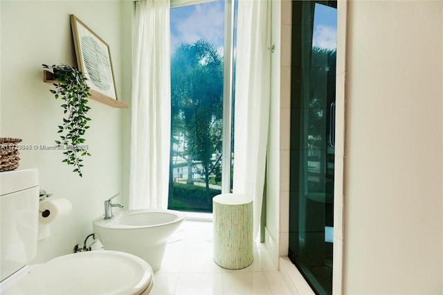 bathroom with tile patterned floors, a bidet, and toilet