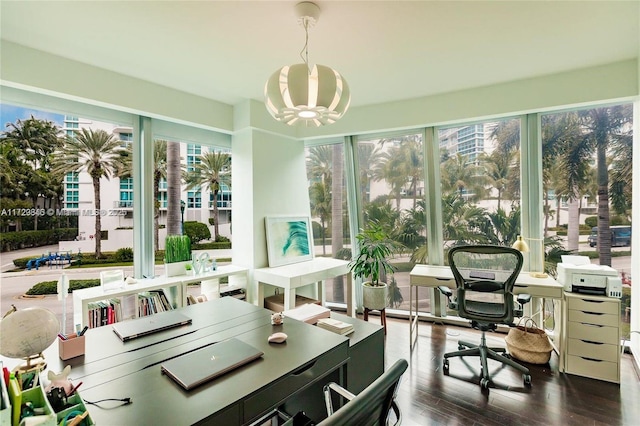 sunroom / solarium featuring a chandelier