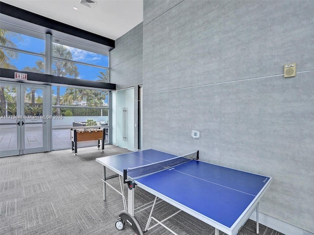 rec room featuring french doors, carpet, and a high ceiling