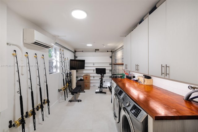 laundry room featuring a wall unit AC and washer and clothes dryer