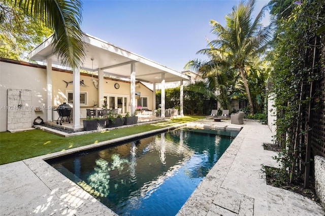 view of pool featuring ceiling fan, a patio, and area for grilling