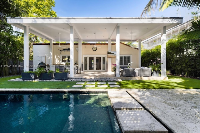 back of property with french doors, outdoor lounge area, a patio, ceiling fan, and a yard