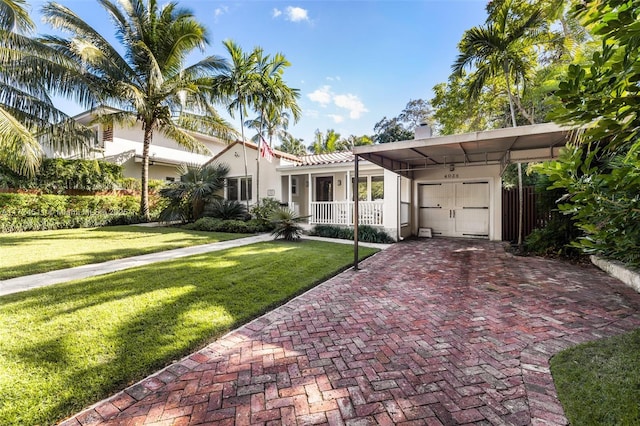 view of front of property with covered porch, a front yard, and a carport