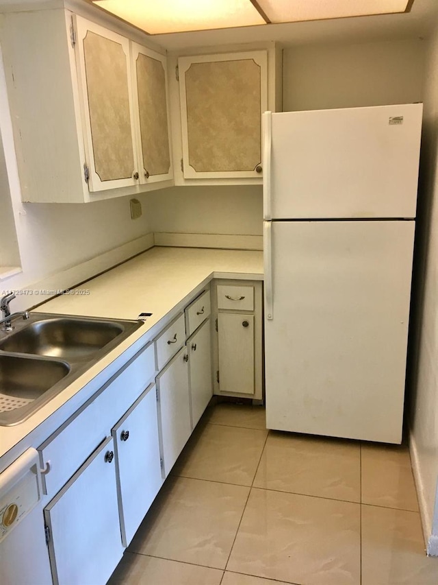 kitchen featuring white cabinetry, sink, white appliances, and light tile patterned flooring