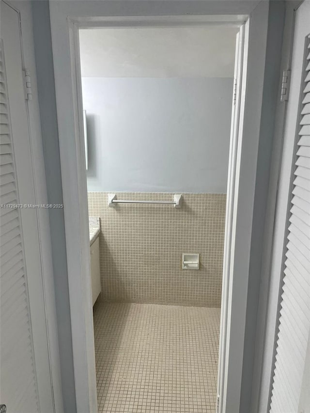 bathroom with tile walls and tile patterned flooring