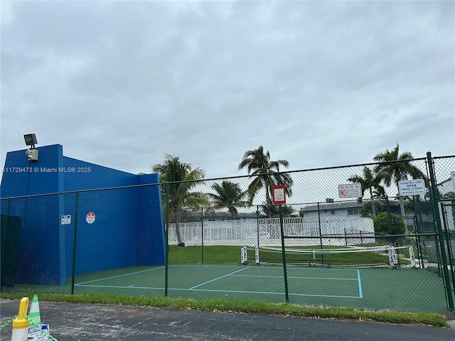 view of tennis court featuring basketball hoop