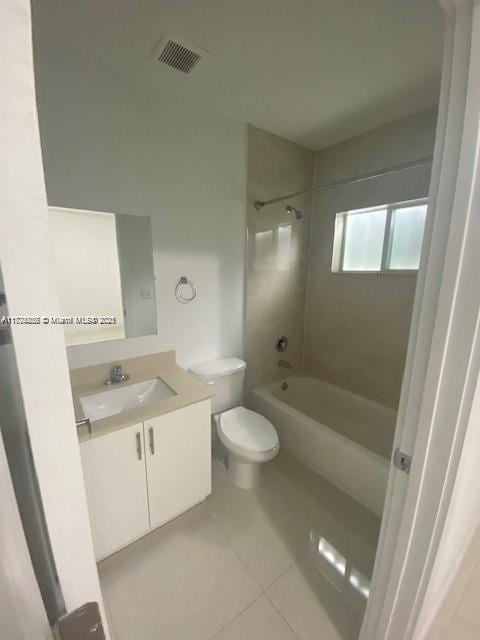 full bathroom with toilet, tiled shower / bath, tile patterned floors, and vanity