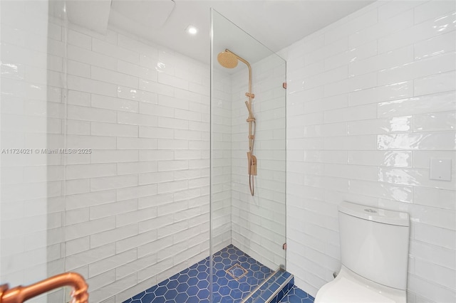 bathroom featuring tiled shower and toilet