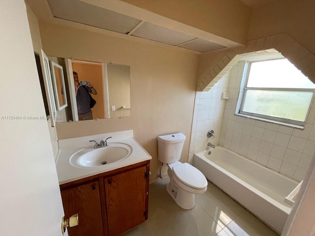 full bathroom featuring vanity, tiled shower / bath, tile patterned floors, and toilet