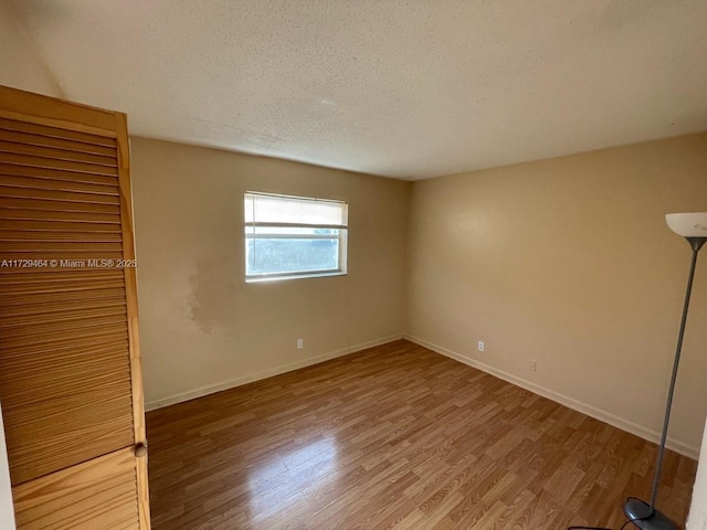 empty room featuring hardwood / wood-style flooring and a textured ceiling