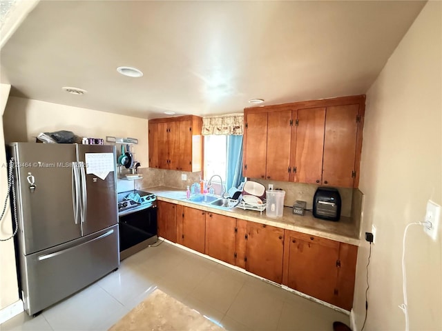 kitchen with sink, backsplash, and appliances with stainless steel finishes