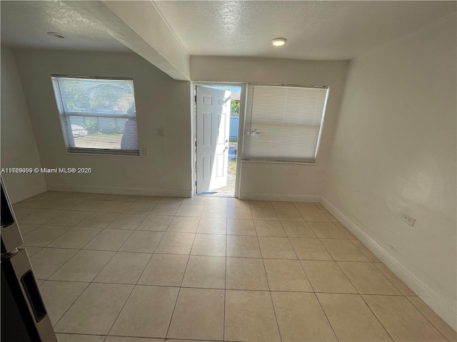 foyer entrance with light tile patterned floors and a textured ceiling