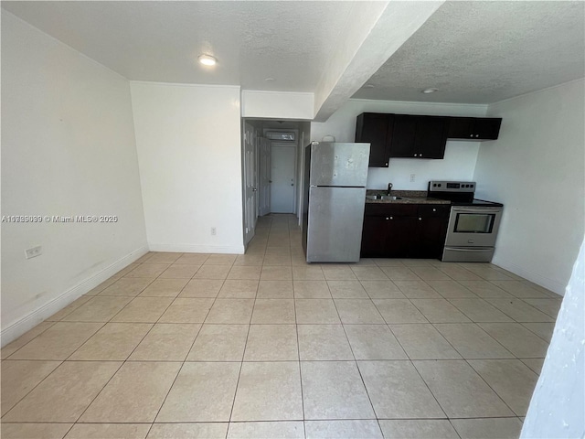 kitchen featuring sink, light tile patterned flooring, a textured ceiling, and stainless steel appliances