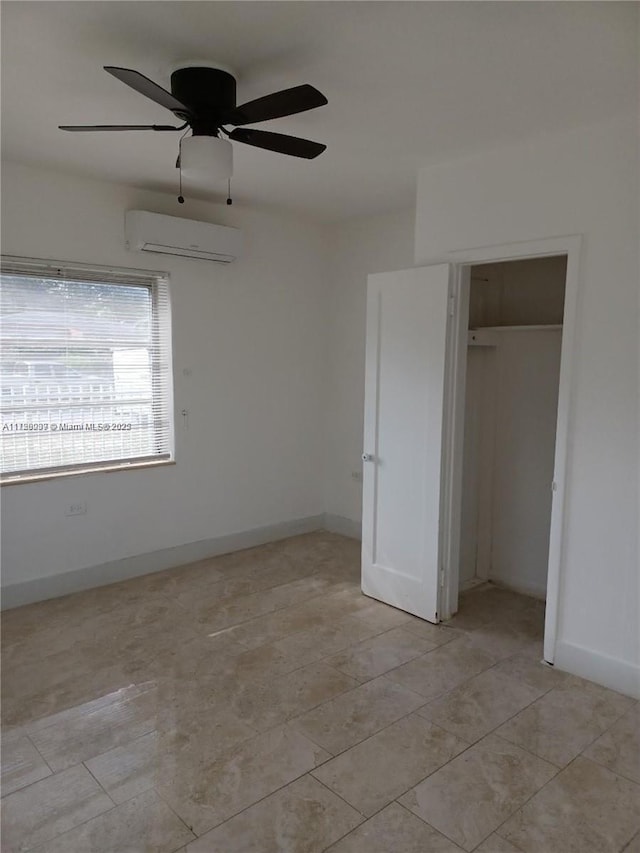 unfurnished bedroom featuring ceiling fan, light tile patterned floors, a closet, and a wall unit AC